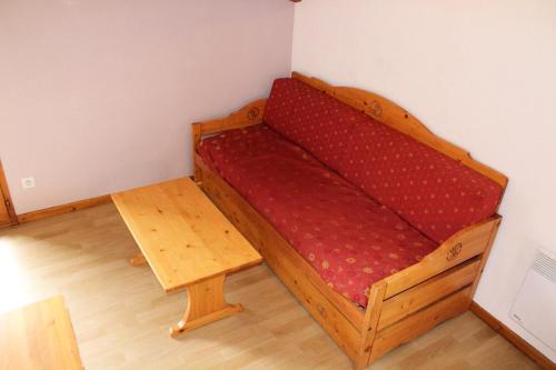 a bed in a room with a red mattress at Les Chalets De Superd Ancolie - 3 Pièces pour 10 Personnes 324 in Le Dévoluy