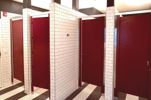 una fila de puestos en un baño con puertas rojas en Chapter San Francisco en San Francisco