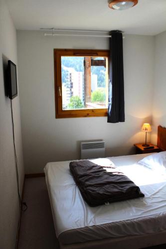 une chambre avec un lit blanc avec une fenêtre dans l'établissement Les Chalets De Superd Heliantheme - 2 Pièces pour 6 Personnes MAE-8484, à Saint-Étienne-en-Dévoluy