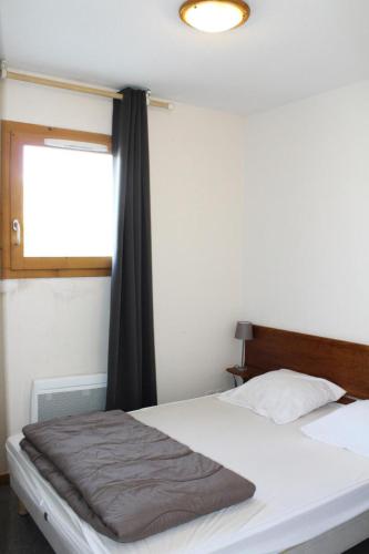 une chambre avec un lit blanc avec une fenêtre dans l'établissement Résidence Les Chaumettes - APPARTEMENT CHAUMETTES A 200 m DES PISTES MAE-8914, à Saint-Étienne-en-Dévoluy