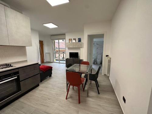 eine Küche und ein Wohnzimmer mit einem Glastisch und Stühlen in der Unterkunft Deluxe comfortable suite with balcony Downtown in Castellanza