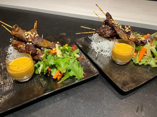 two plates of food with meat and vegetables and drinks at Sans Souci Bed and Breakfast Luxe Heated Pool and Restaurant in Luzillé