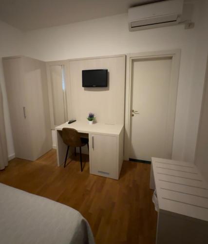 a bedroom with a desk and a bed and a television at Hotel La Pace in Pontedera