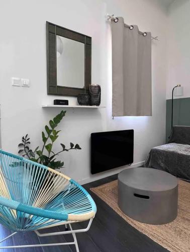un salon avec une chaise bleue et une télévision dans l'établissement Le Duplex, à Six-Fours-les-Plages