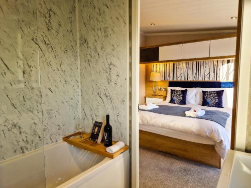 a bathroom with a bed and a tub and a bedroom at Hotchkin Lodge in Woodhall Spa