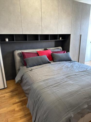 een slaapkamer met een groot bed met rode kussens bij Deluxe comfortable suite with balcony Downtown in Castellanza