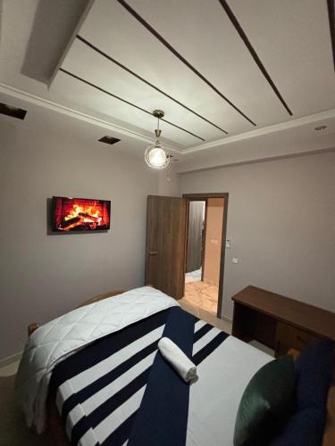 1 dormitorio con 1 cama y TV en la pared en Résidence les Jardin d Anass Aéroport Marrakech, en Marrakech