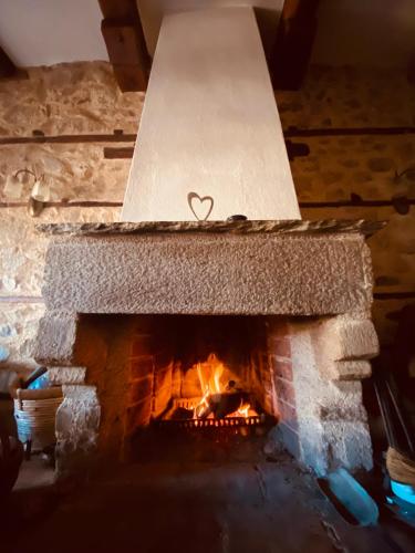 a stone fireplace with a heart on top of it at Aristotelous Alexandrou Historic Inn in Arnaia