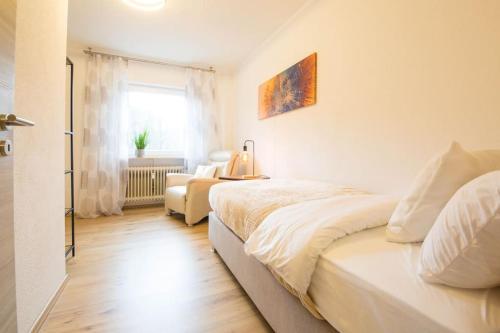 a white bedroom with a bed and a window at Homefeeling Apartment am Eisweiher Park in Pirmasens