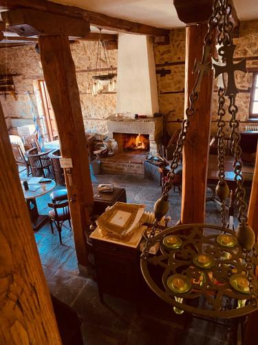 a living room with a fireplace and a room with a table at Aristotelous Alexandrou Historic Inn in Arnaia