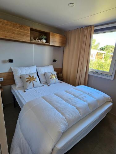 a large white bed in a bedroom with a window at Casa Luisa Mobil Home in Canet-en-Roussillon