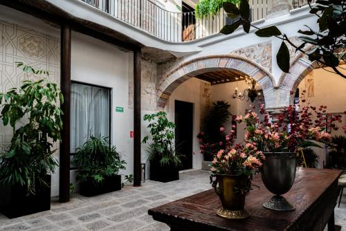a room with a table with vases of flowers on it at HOTEL BOUTIQUE CASONA 65 in Puebla