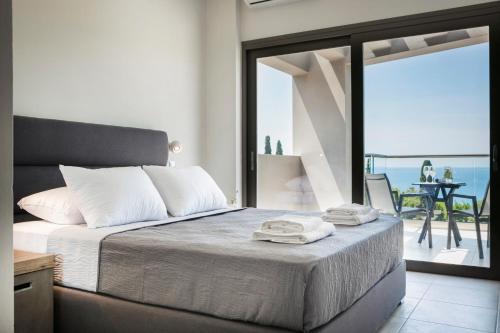 a bedroom with a bed with a view of the ocean at Escape Villa Kefalonia in Lourdata