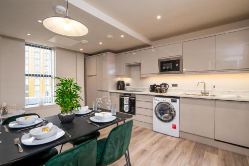 eine Küche und ein Esszimmer mit einem Tisch und Stühlen in der Unterkunft Luxury Serviced Penthouse - City Centre - En Suite Bedrooms - Free Netflix in Leeds