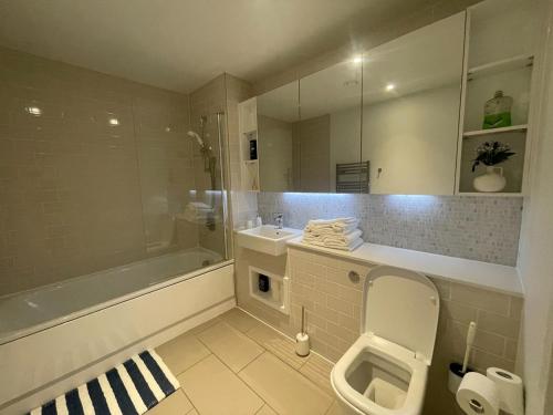 een badkamer met een toilet, een wastafel en een bad bij Large 2 Bed Apartment London Close to Lewisham Hospital - Perfect for Long Stay in Londen