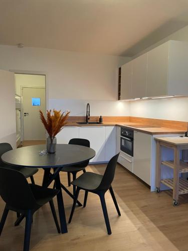 a kitchen with a table and chairs in a room at Fully renovated studio with nice view! in Nieuwpoort