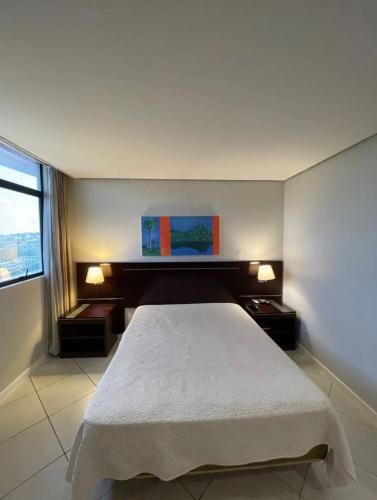 a bedroom with a white bed and a window at Manaus hotéis millennium flat in Manaus