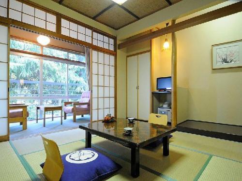 a living room with a table in a room at Wakatake in Tagami