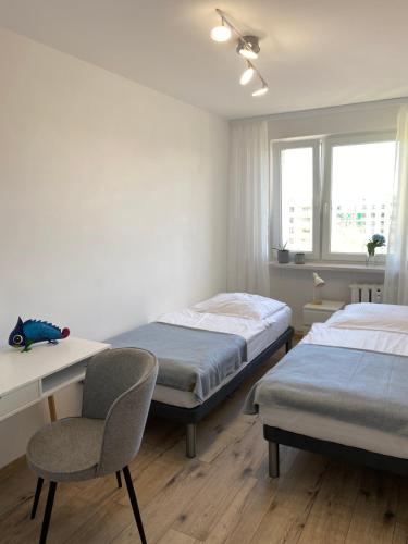 een slaapkamer met 2 bedden, een bureau en een stoel bij Apartament Kasia in Wałbrzych