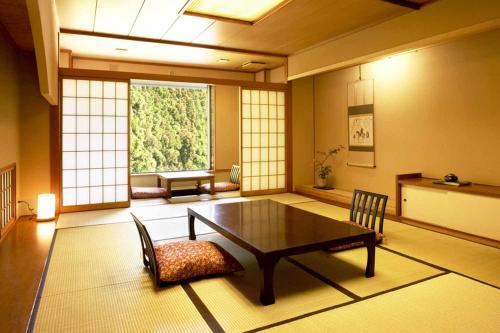 a room with a table and chairs and a window at Wakatake in Tagami