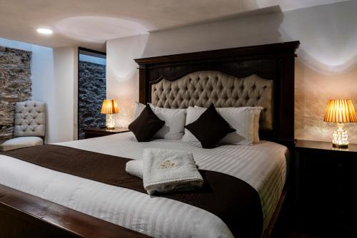 a bedroom with a large bed and two lamps at HOTEL BOUTIQUE CASONA 65 in Puebla
