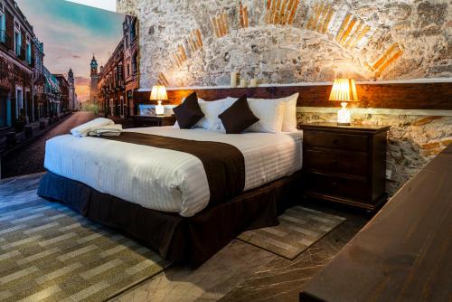 a bedroom with a large bed and a stone wall at HOTEL BOUTIQUE CASONA 65 in Puebla