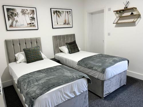 two beds in a hotel room with twoitures at Stunning 3 BED 2BATH house w/parking in Reading
