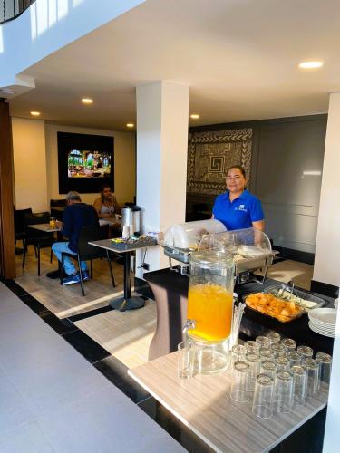 Ein Mann steht in einem Restaurant mit einem Buffet. in der Unterkunft DUSANO BOUTIQUE HOTEL in Santa Marta