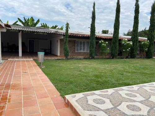 a house with a green yard with trees at Finca Rozo in Palmira