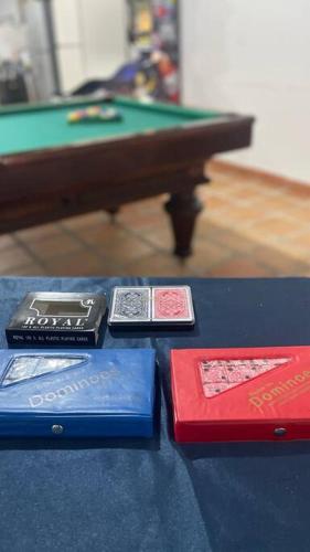 quattro libri su un tavolo accanto a un tavolo da biliardo di Finca Rozo a Palmira