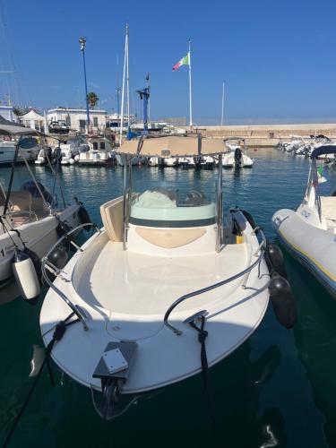 a white boat is docked in the water at Antares In Puglia in Monopoli