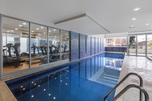 uma piscina com um ginásio e um centro de fitness em Oaks Glenelg Liberty Suites em Adelaide