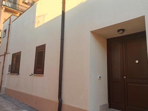 a building with a door and two windows on it at La Rizzaia casa indipendente in Trapani