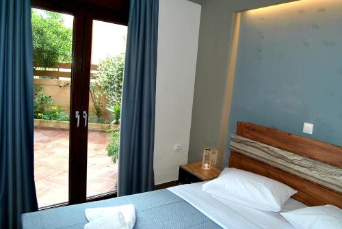 a bedroom with a bed and a large window at Olympus House in Litochoro