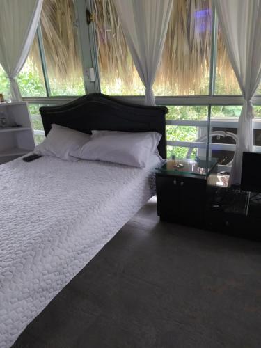 een slaapkamer met een wit bed en een groot raam bij Huil Tana in La Figueroa