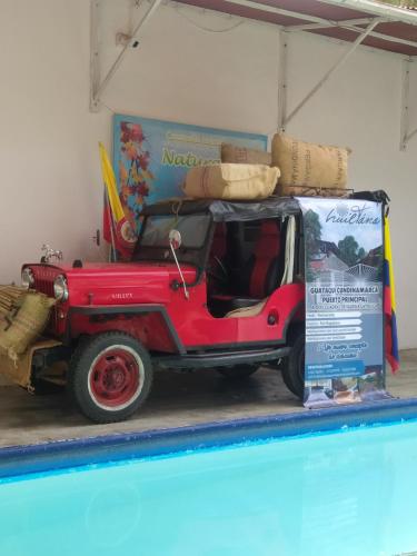 een rode jeep geparkeerd in een garage met een bord bij Huil Tana in La Figueroa