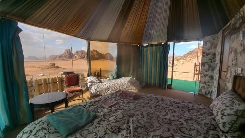 a bedroom with a bed and a view of the desert at Al Raha Luxury Camp in Wadi Rum