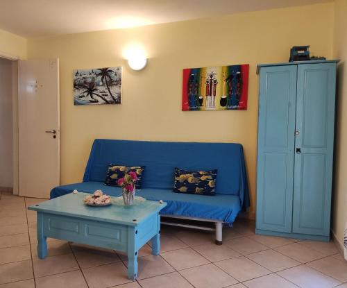 a living room with a blue couch and a table at Residence Amanda with pool in Santa Maria