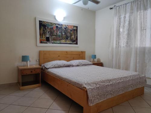 a bedroom with a bed and two tables and a window at Residence Amanda with pool in Santa Maria