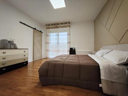 バスティーア・ウンブラにあるBastia Home Appartamentoのベッドルーム1室(ベッド1台、ドレッサー、窓付)