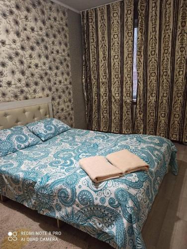 een slaapkamer met een bed met twee handdoeken erop bij Nayrizbai batira 2 in Alma-Ata