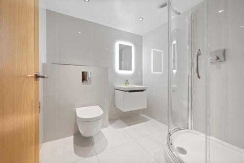 a white bathroom with a toilet and a shower at White Hart Hotel & Apartments in Harrogate
