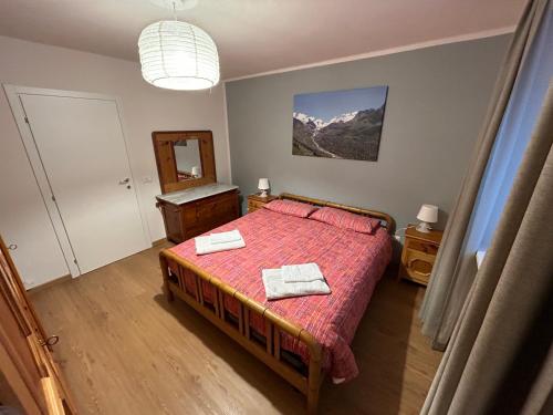 1 dormitorio con 1 cama con 2 toallas en Residenza Sertorelli, en Bormio