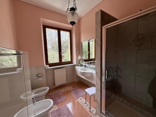 een badkamer met 2 toiletten, een douche en een wastafel bij La Casa Del Contadino in Bevagna