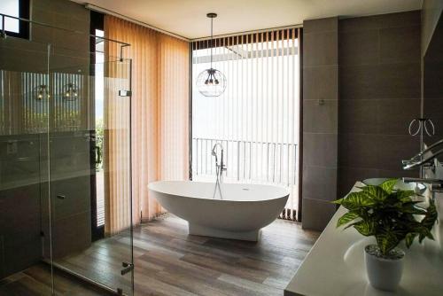 uma casa de banho com banheira e uma planta em Villa Los tres Diamantes em Copacabana