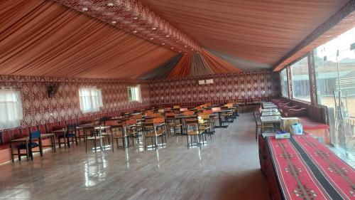 a large room with tables and chairs in it at Al Raha Luxury Camp in Wadi Rum