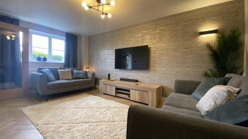a living room with a couch and a tv at Whittaker Mews near Alton Towers JCB in Rocester