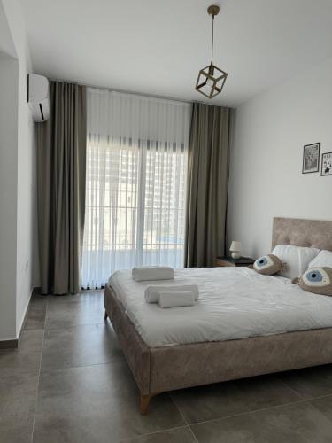 a bedroom with a large bed and a large window at Caesar Resort & SPA Commodus in Iskele