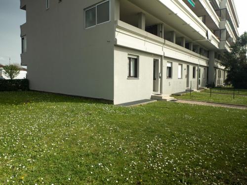 a building with a grassy yard next to a building at Oasi Verde Udinese Charme nel Cuore della Città in Udine