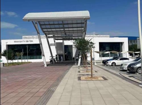 a parking lot with cars parked in front of a building at A Place to Stay 1BR Waters Edge Theme Parks, Yas Island in Abu Dhabi